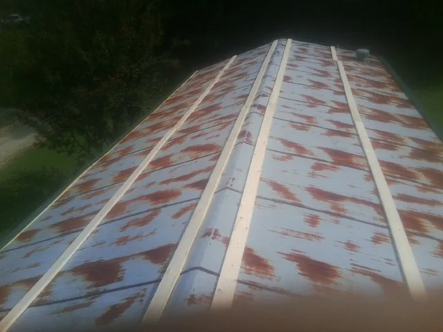 Rusted metal roof panels with new wood purlins before replacement — Storm Damage Roof Repair in Middle Island by Roofing Brothers