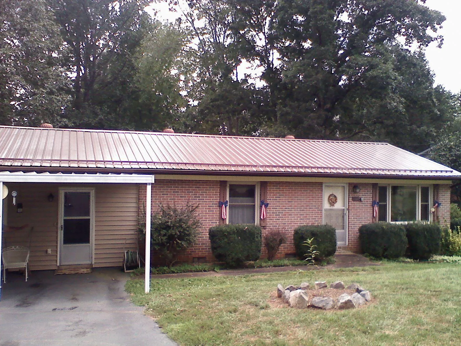 Bronze metal roof and carport on a brick ranch home — Roof Repair work by our crew in Middle Island